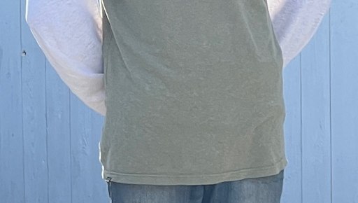Close view of the olive hemp-blend cloth and hem on the pre-production Fieldline Tee sample. No face is shown.